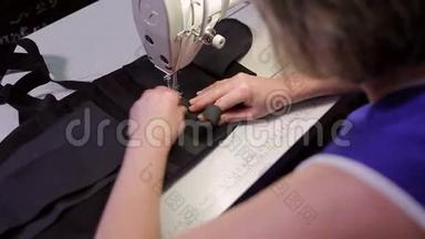 女人缝把胶带<strong>延伸</strong>到产品上。